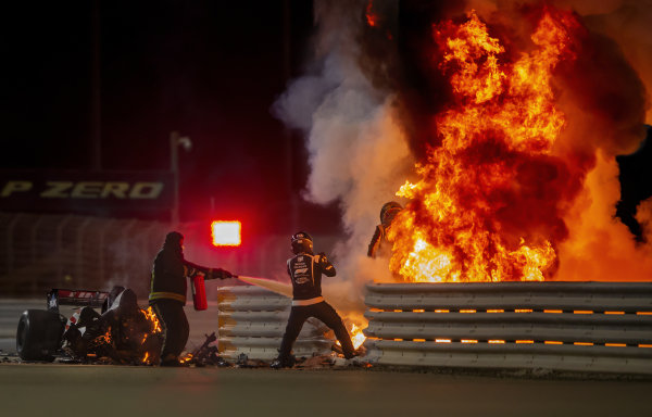Romain Grosjean, Haas F1, emerges from flames after a horrific accident on the opening lap of the Bahrain Grand Prix. Marshals extinguish the fire Romain Grosjean, Haas F1, emerges from flames after a horrific accident on the opening lap of the Bahrain Grand Prix. Marshals extinguish the fire